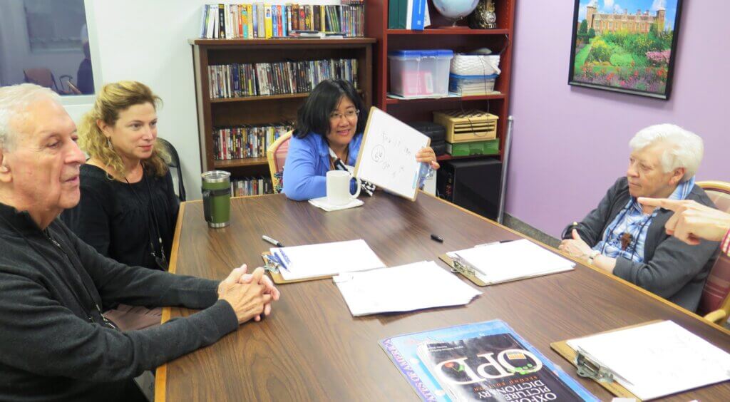 group of elderly people talking around a table
